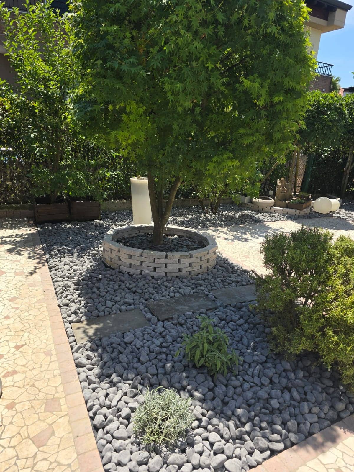 Aiuola con ciottoli grigi attorno a un albero